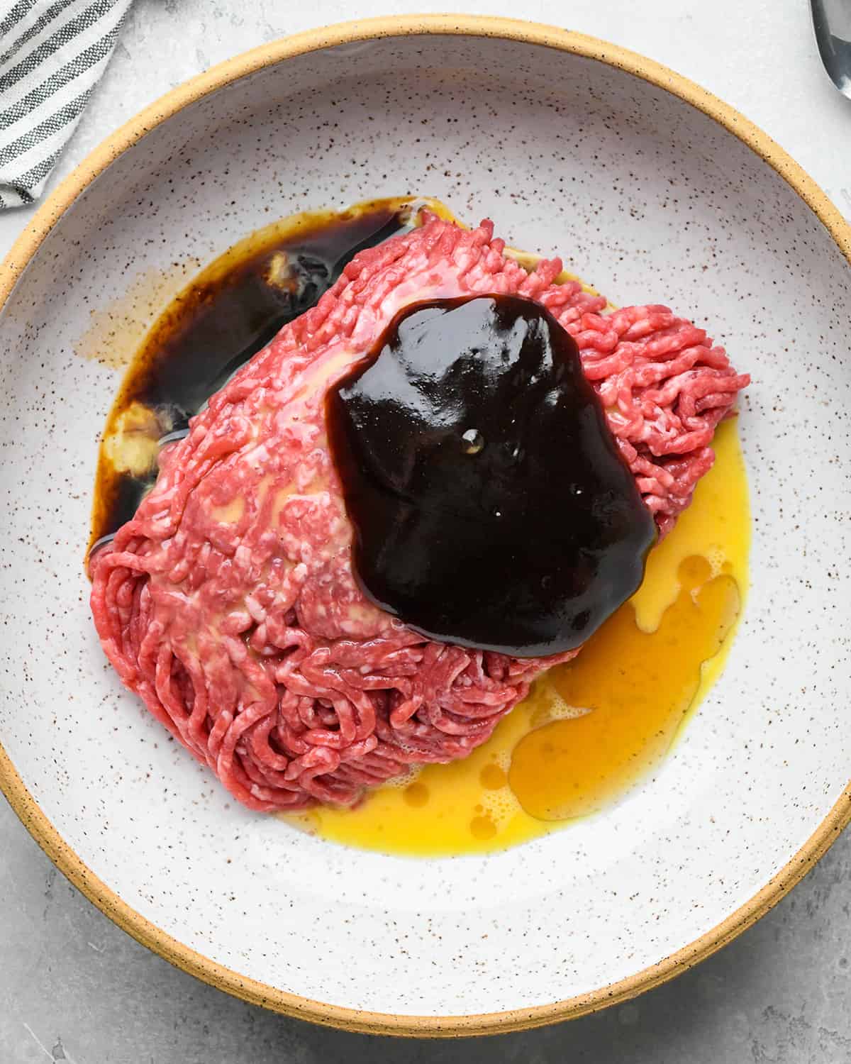 ground beef and wet Asian Meatballs ingredients in a bowl before mixing