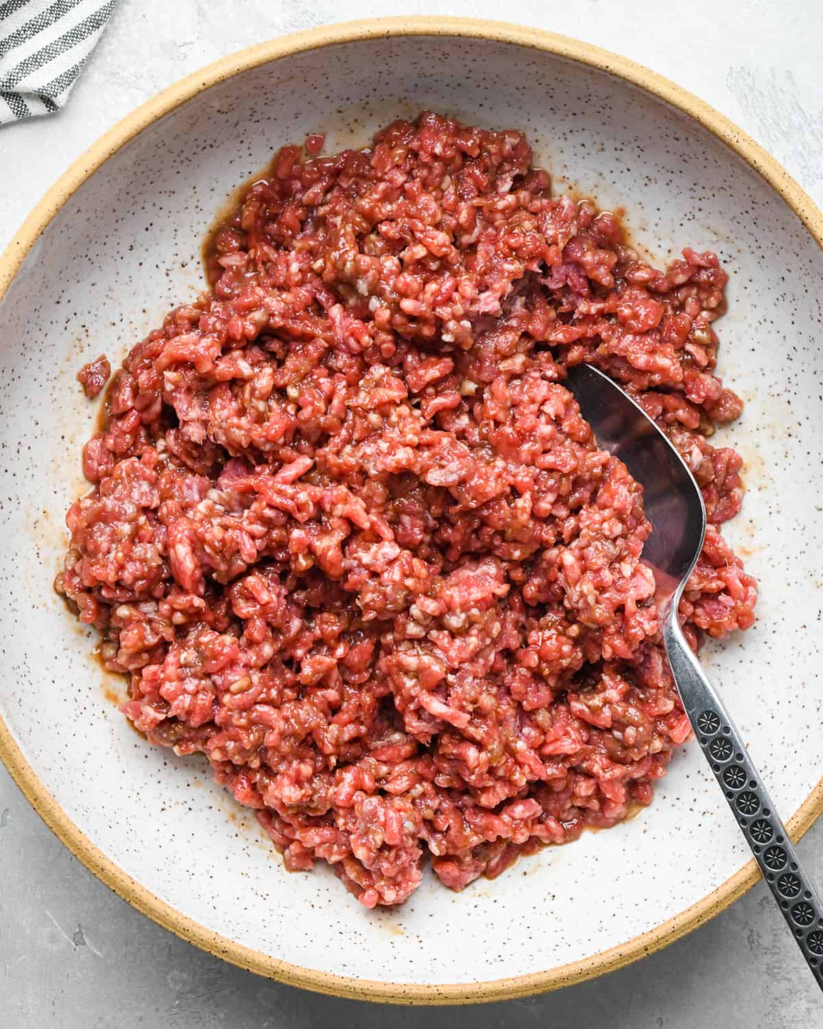 ground beef and wet Asian Meatballs ingredients in a bowl after mixing