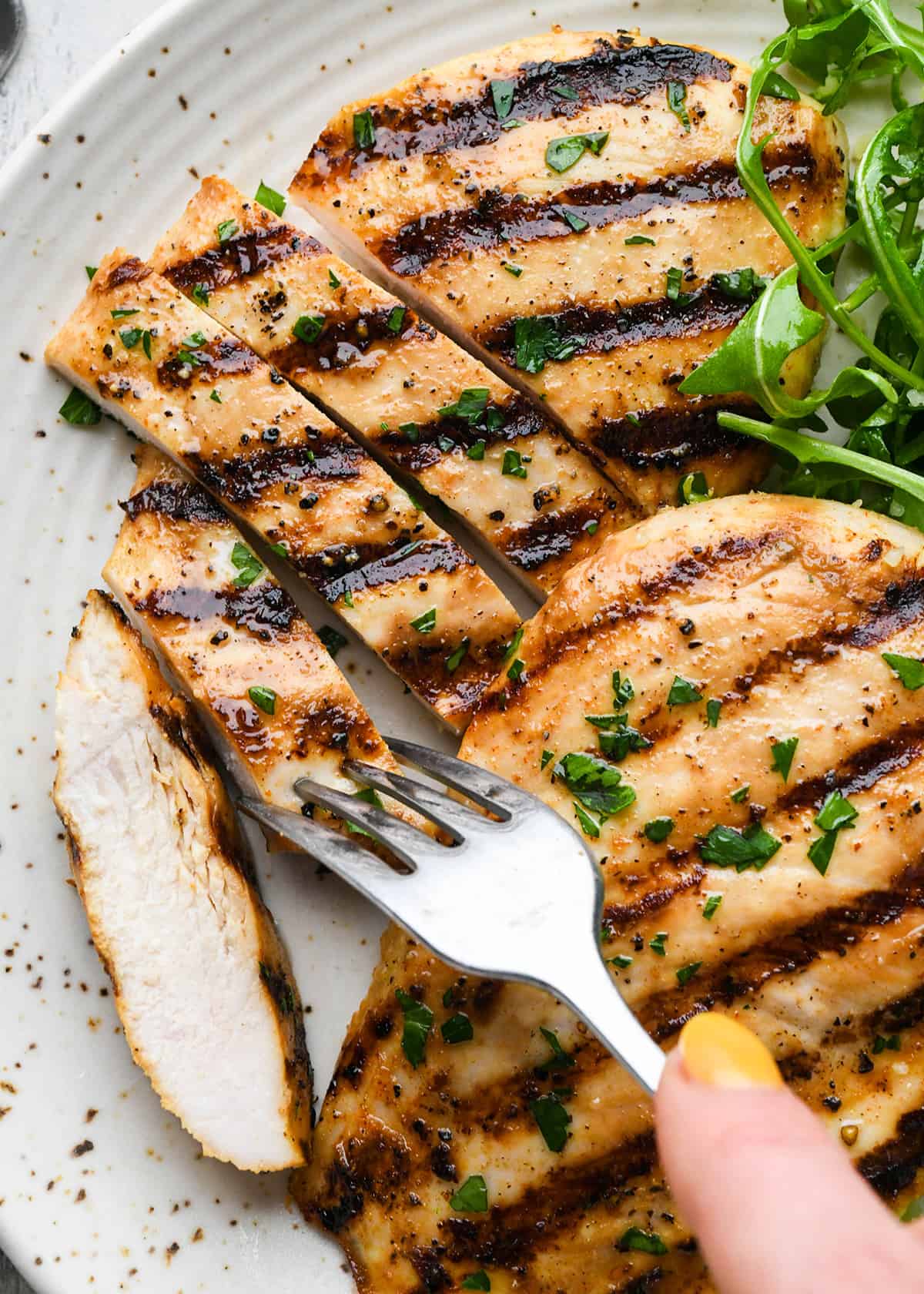 a fork taking a piece of Buttermilk Chicken breast from a plate