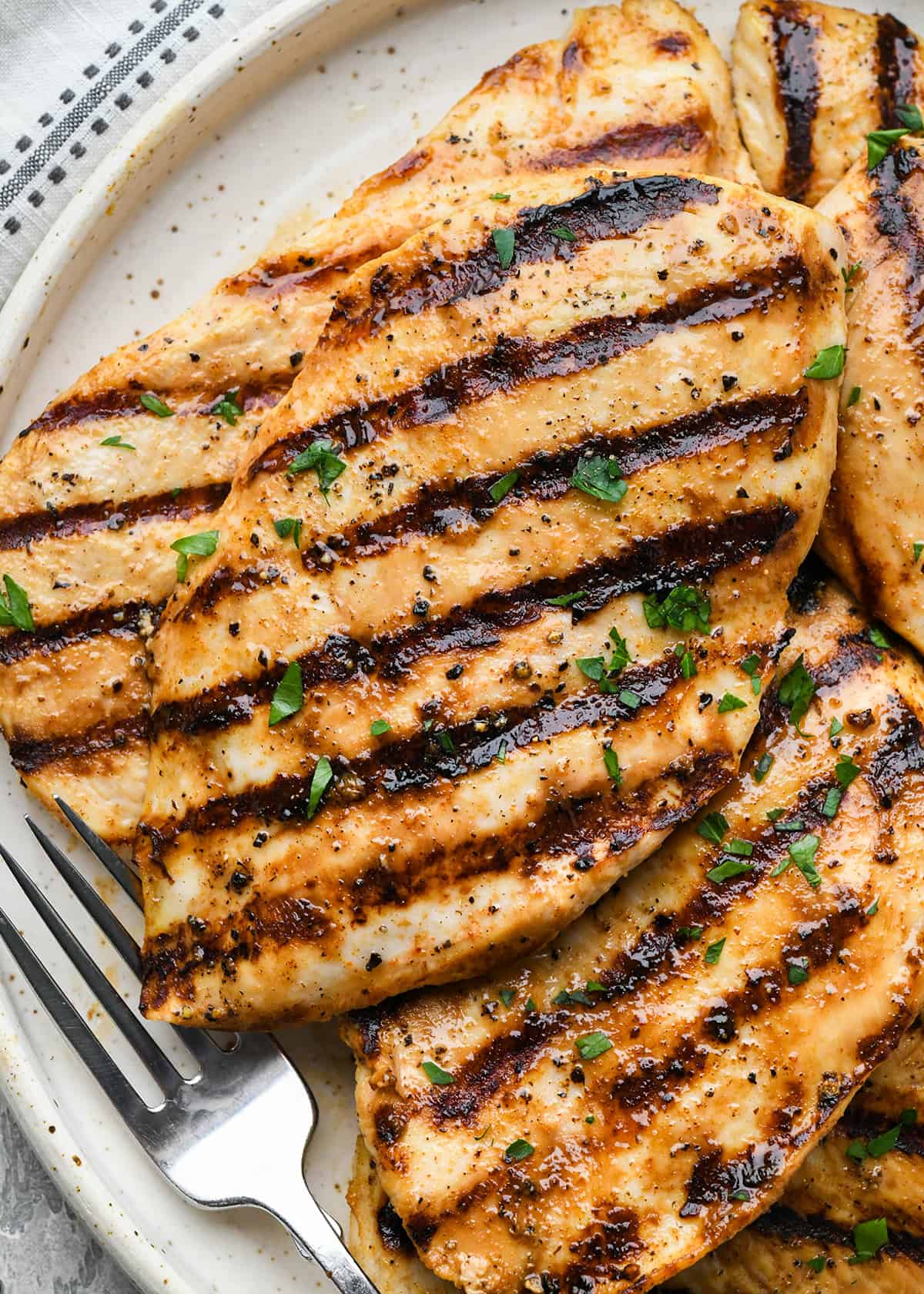 5 poitrines de poulet au babeurre garnies de persil sur une assiette