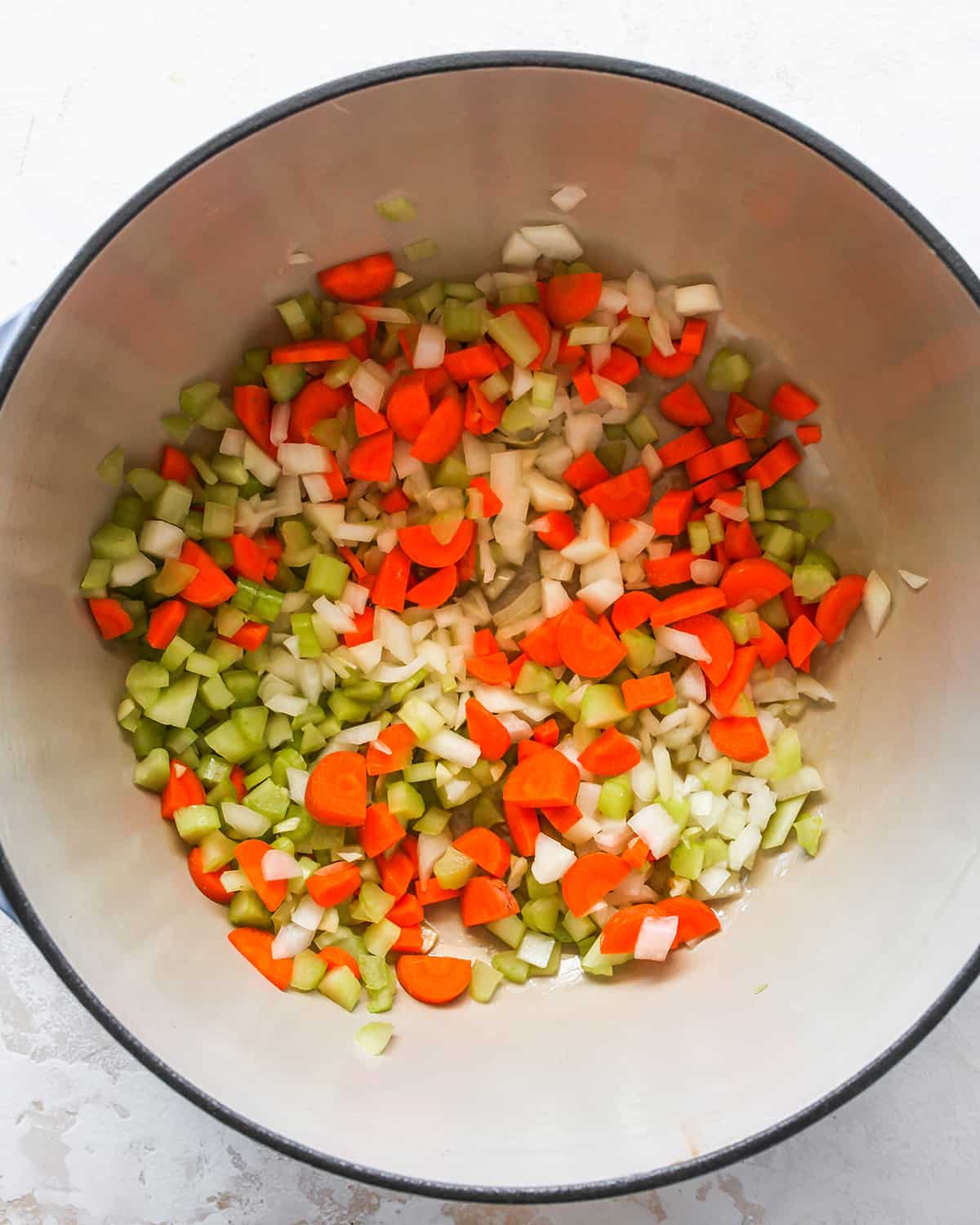 Vegetables and olive oil in a stockpot before cooking to make chicken noodle soup