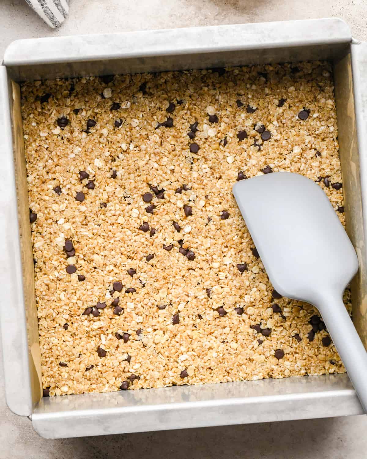 granola bar recipe mixture poured into a baking dish after spreading