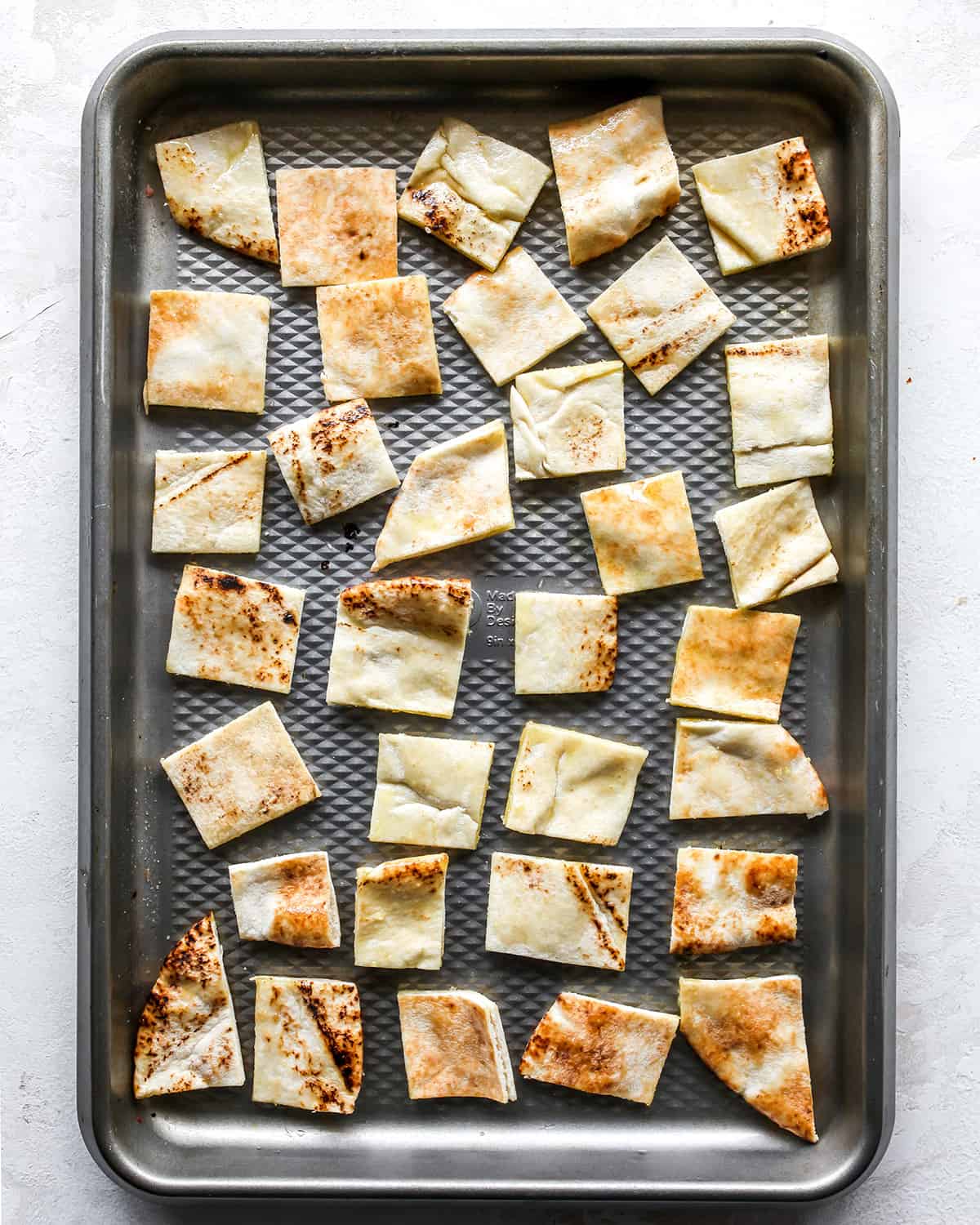 how to make greek salad - pita croutons on a baking sheet before baking
