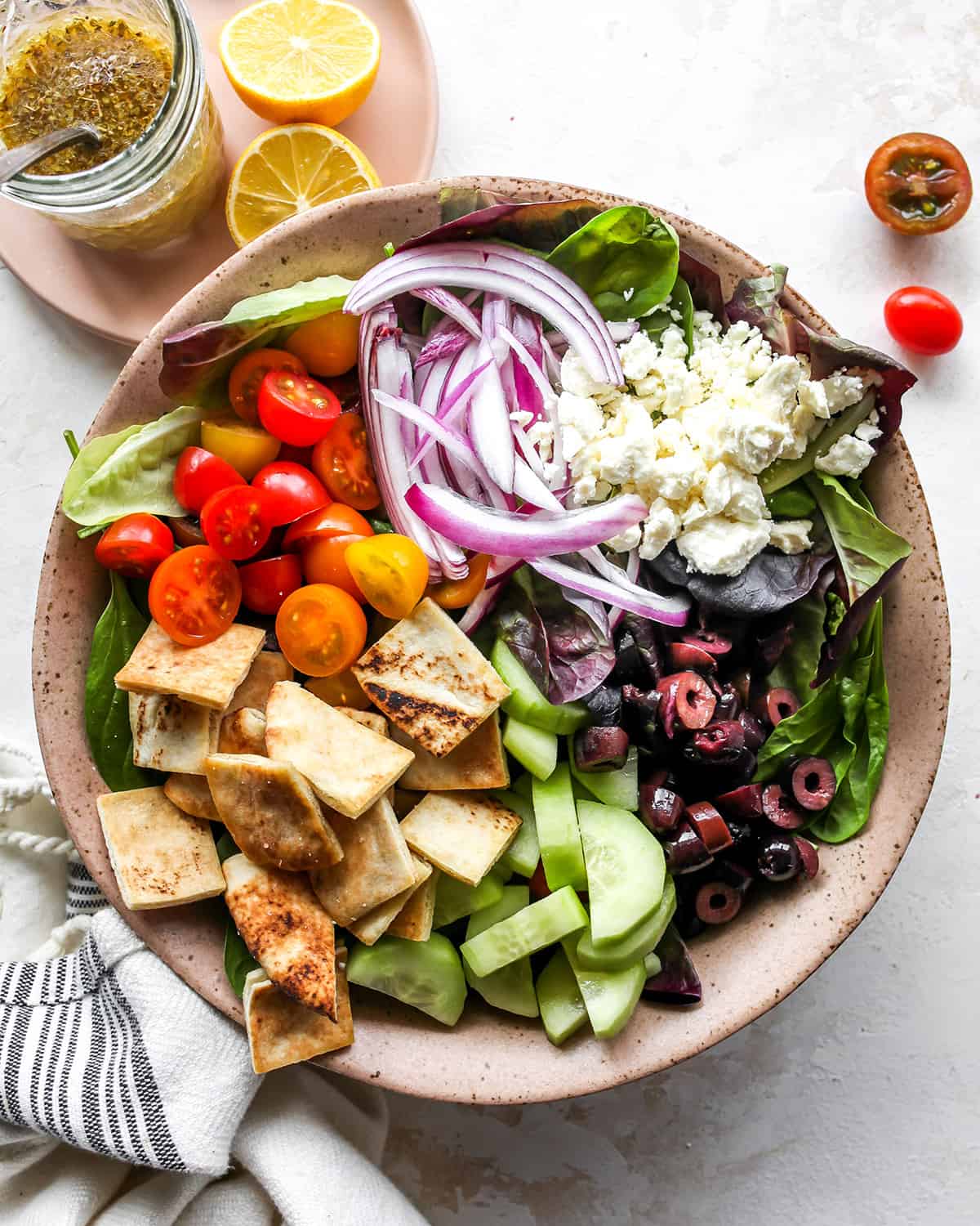 assembling Greek Salad Recipe in a bowl