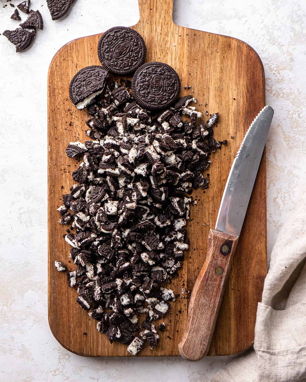 coarsely chopped oreos on a wooden cutting board to make oreo pie
