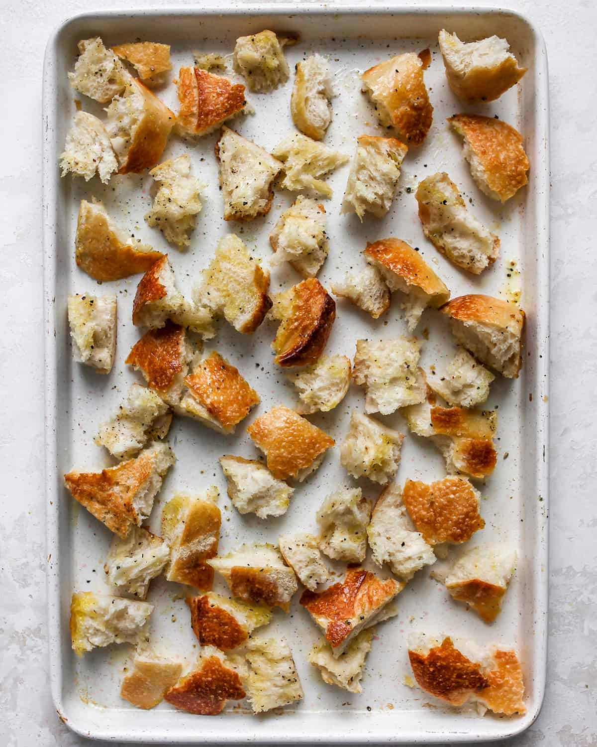 bread on a baking sheet before toasting to use in this panzanella salad recipe