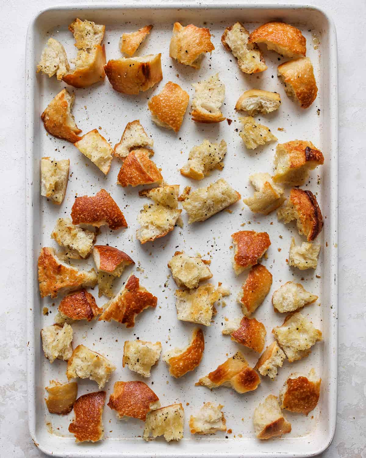 bread on a baking sheet after toasting to use in this panzanella salad recipe