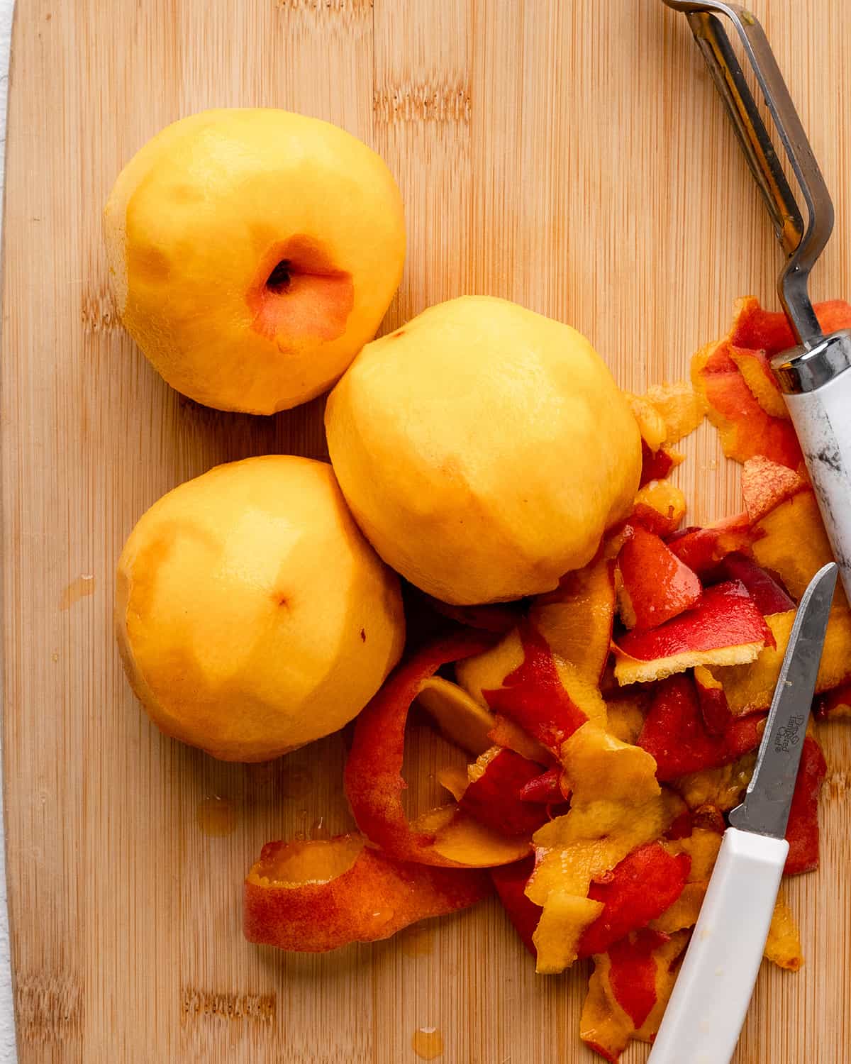 How to Make Peach Cheesecake - 3 peaches peeled on a cutting board