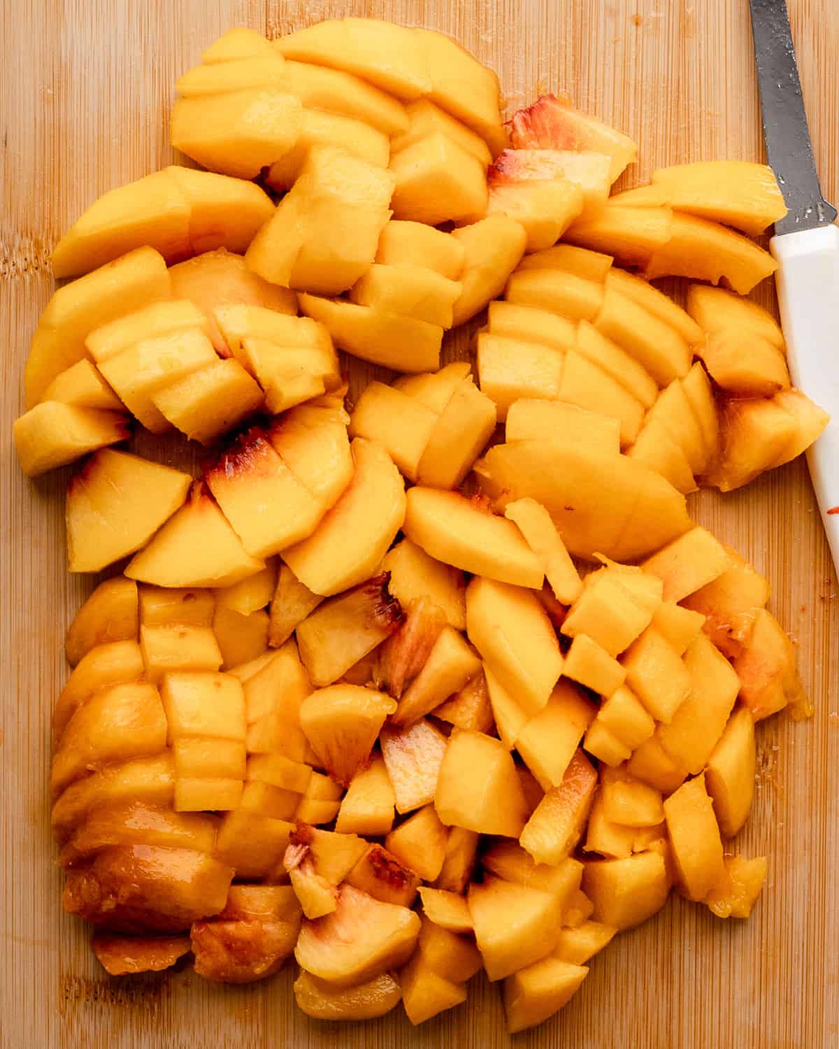 How to Make Peach Cheesecake - 3 peaches sliced on a cutting board
