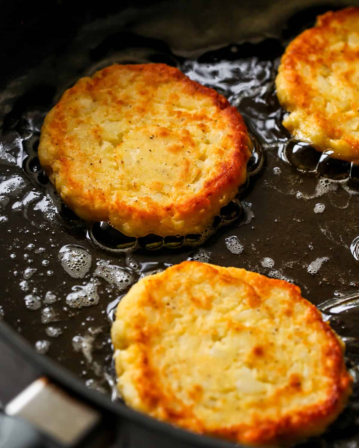 How To Make Potato Pancakes - cooking potato pancakes on the second side in an oiled skillet