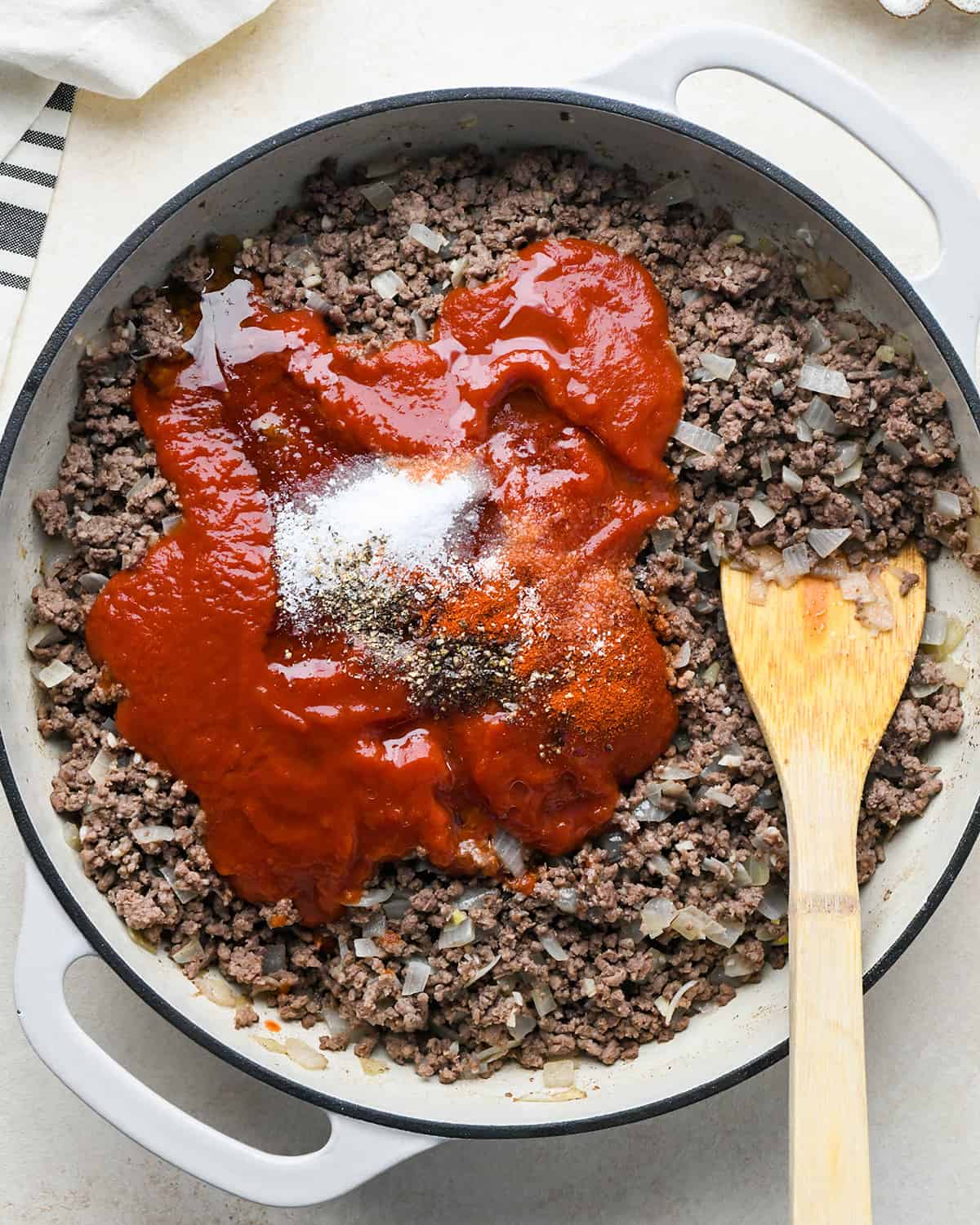 How to Make Sloppy Joes - adding tomato sauce, honey, salt, pepper and paprika before stirring