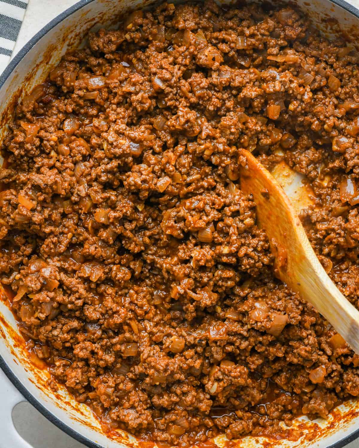 final sloppy joes recipe after cooking in a pot with a wooden spoon