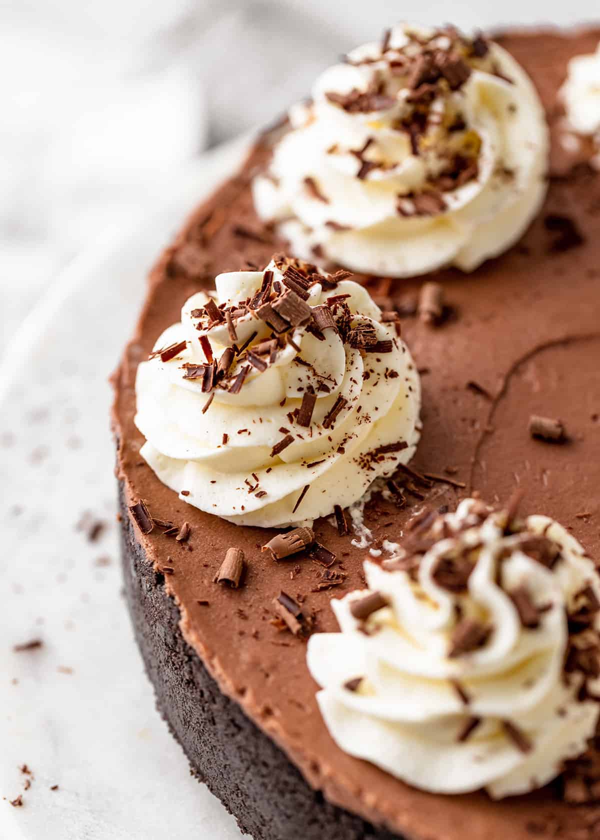 No Bake Chocolate Cheesecake topped with whipped cream and chocolate shavings
