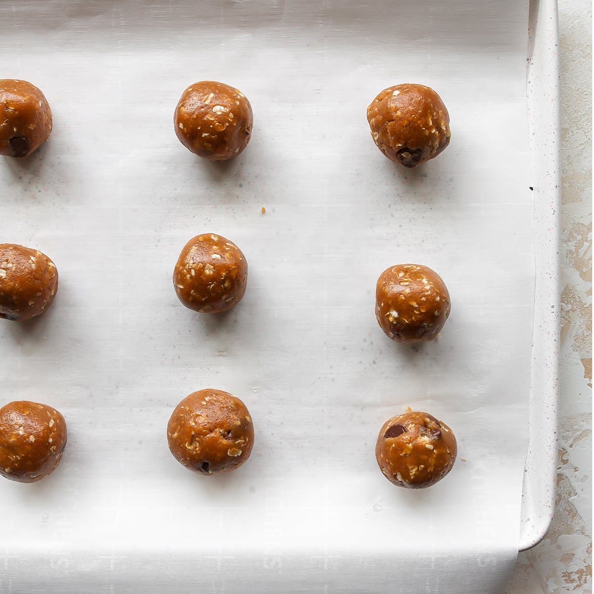 9 Peanut Butter Oatmeal Cookie dough balls on a baking sheet before baking