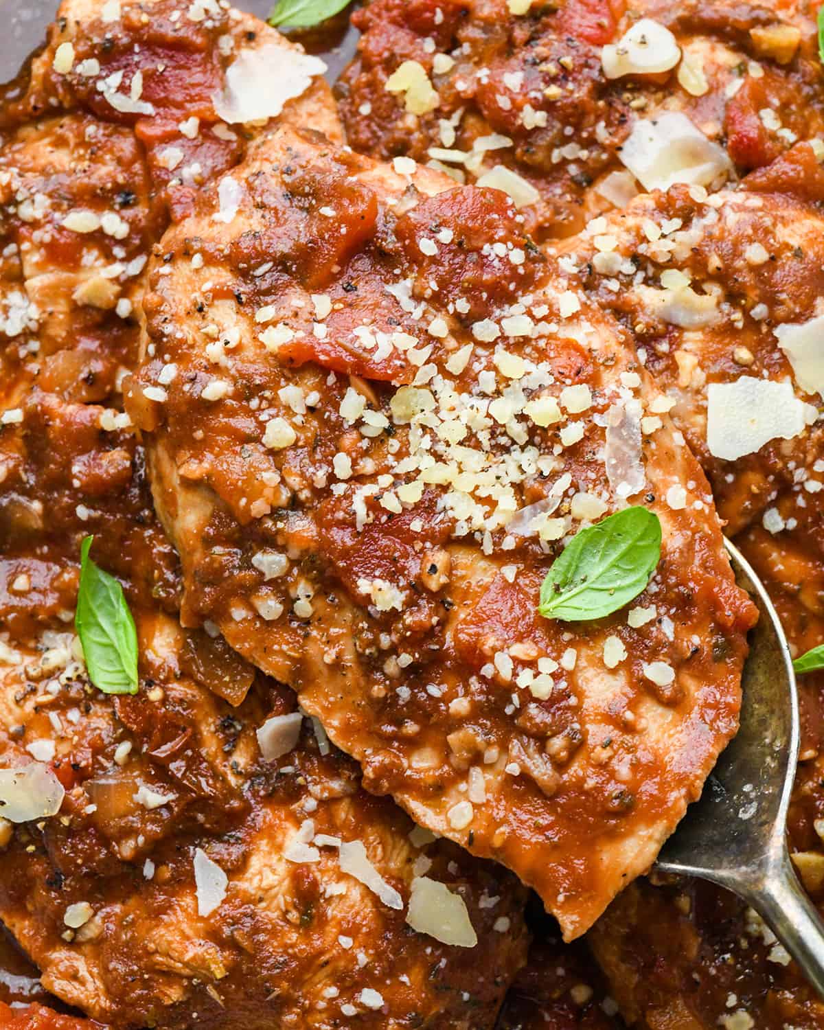 up close photo of Slow Cooker Italian Chicken garnished with parmesan cheese and basil