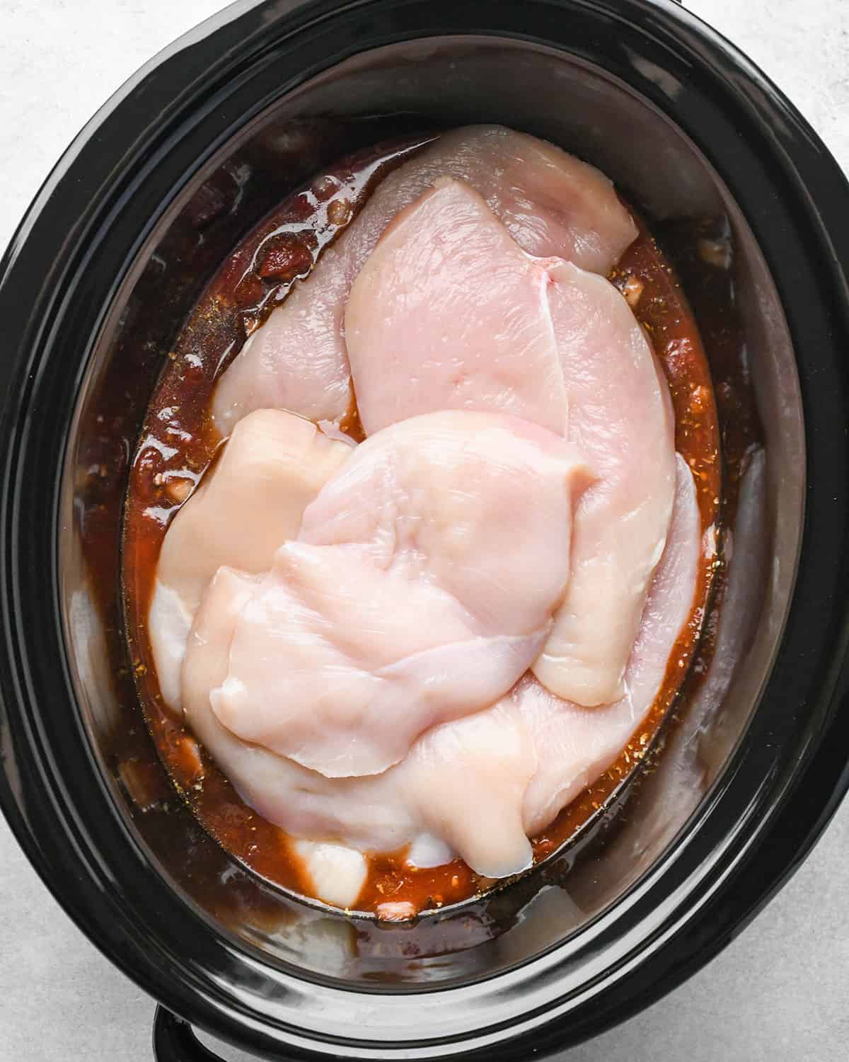 chicken breasts added to the sauce before mixing in this crockpot italian chicken recipe