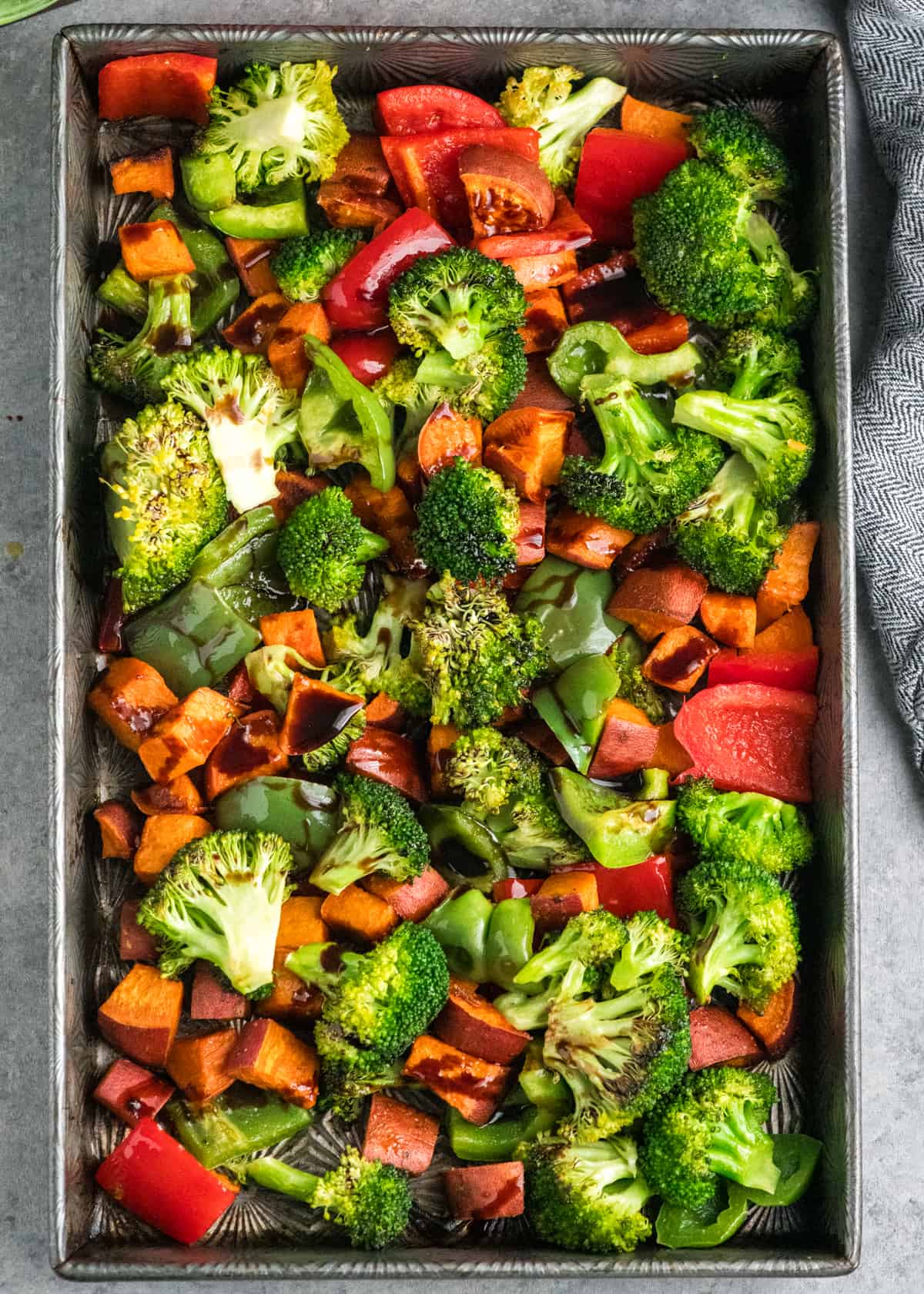 vegetables with balsamic vinegar poured on top in a baking pan