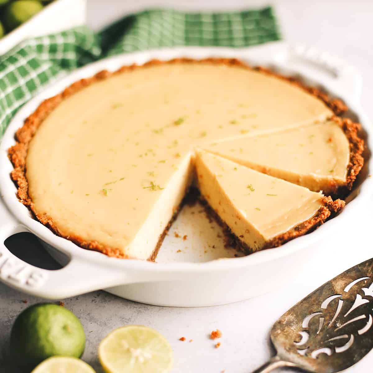 Key Lime Pie in a pie dish with 2 slices cut out of it