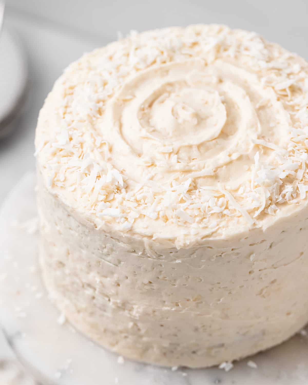 Coconut Cake frosted with coconut frosting and sprinkled with shredded coconut