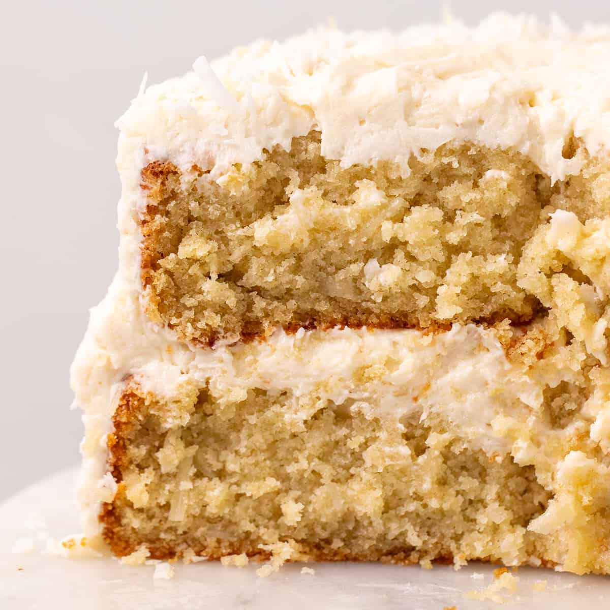 front view of a Coconut Cake with a slice cut out of it