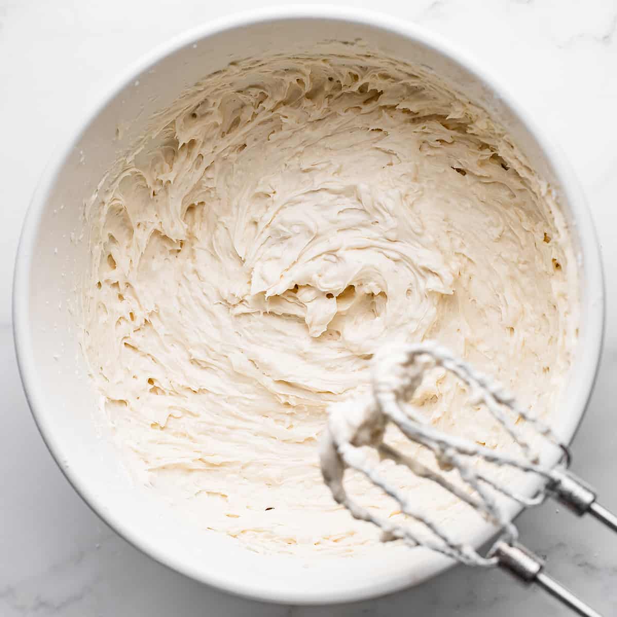 how to make coconut cake- a bowl of coconut frosting