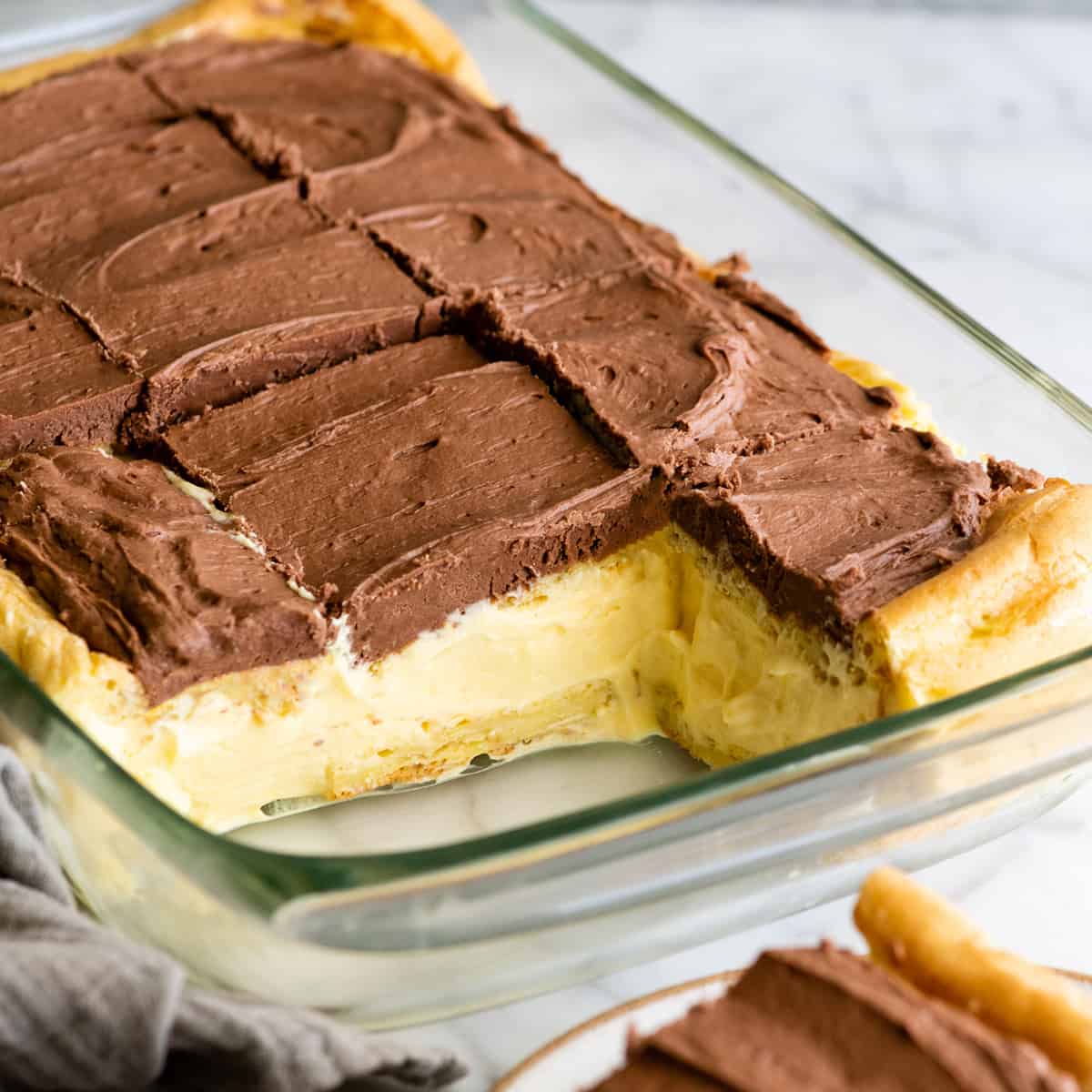 Chocolate Eclair Cake in a baking dish with 2 pieces cut out of it
