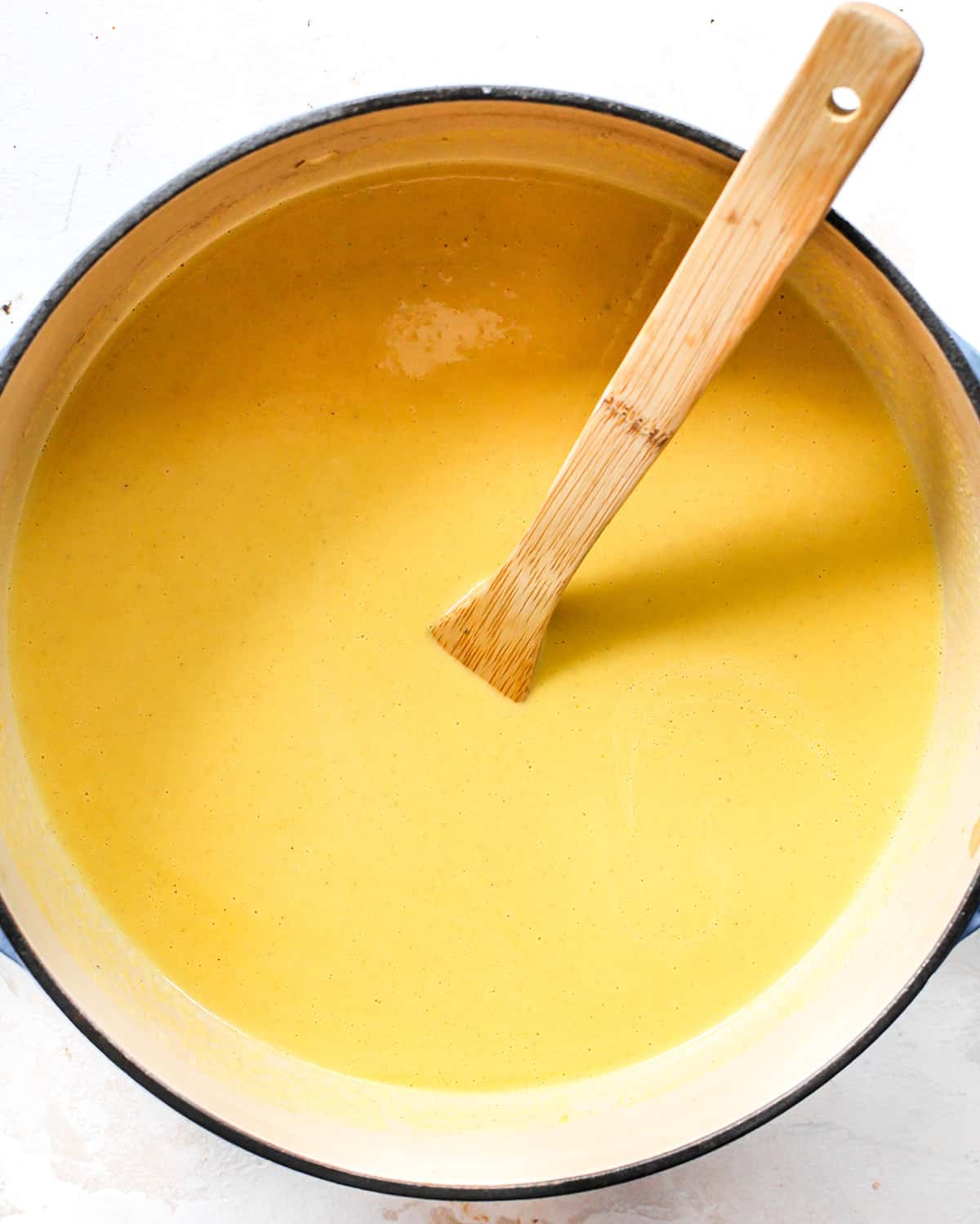 How to Make Butternut Squash Soup finished soup in a pot with a wooden spoon