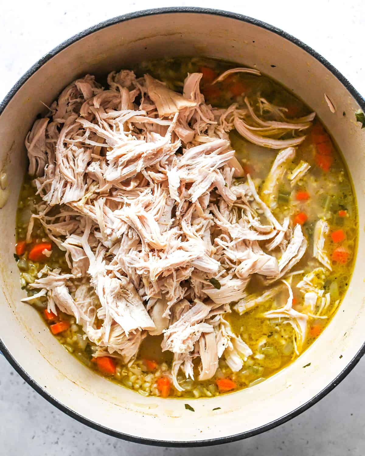 how to make Chicken Rice Soup - shredded chicken added back to the pot before stirring