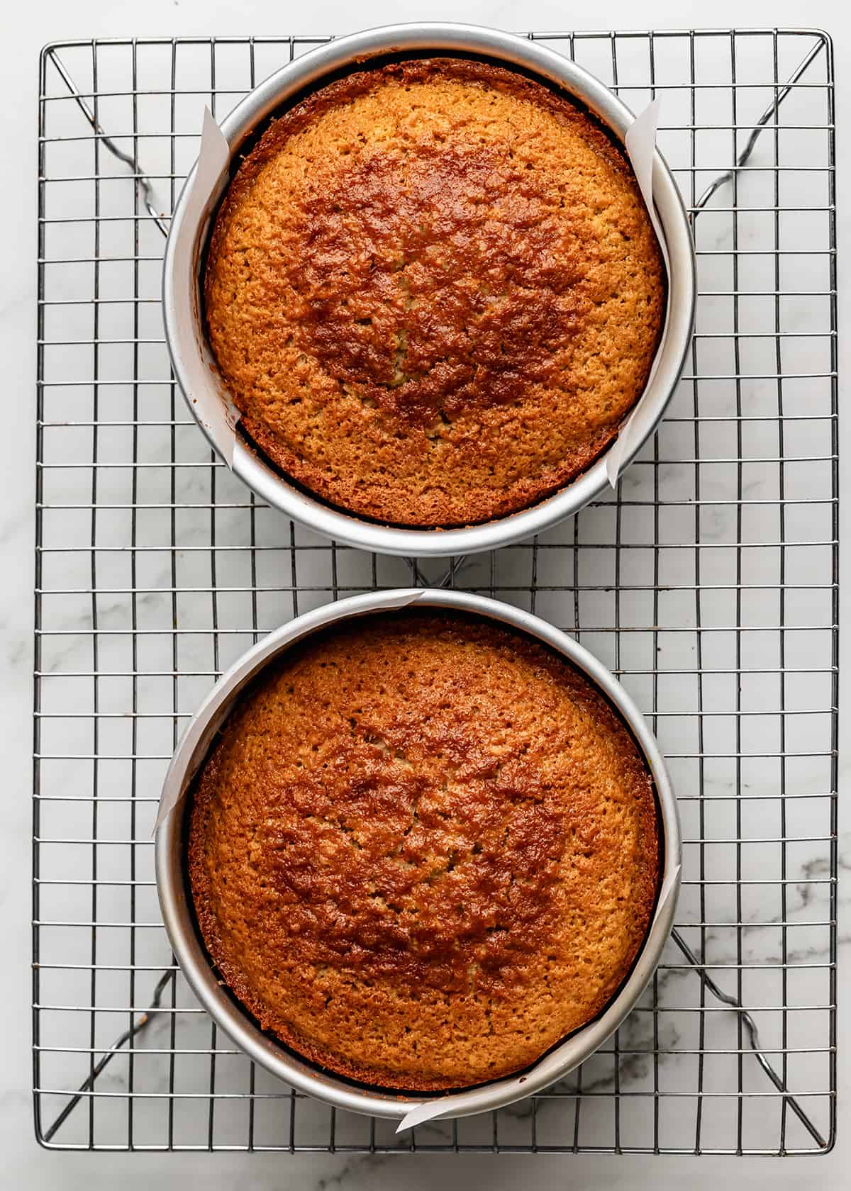 how to make coconut cake- baked cakes in two pans on a wire cooling rack