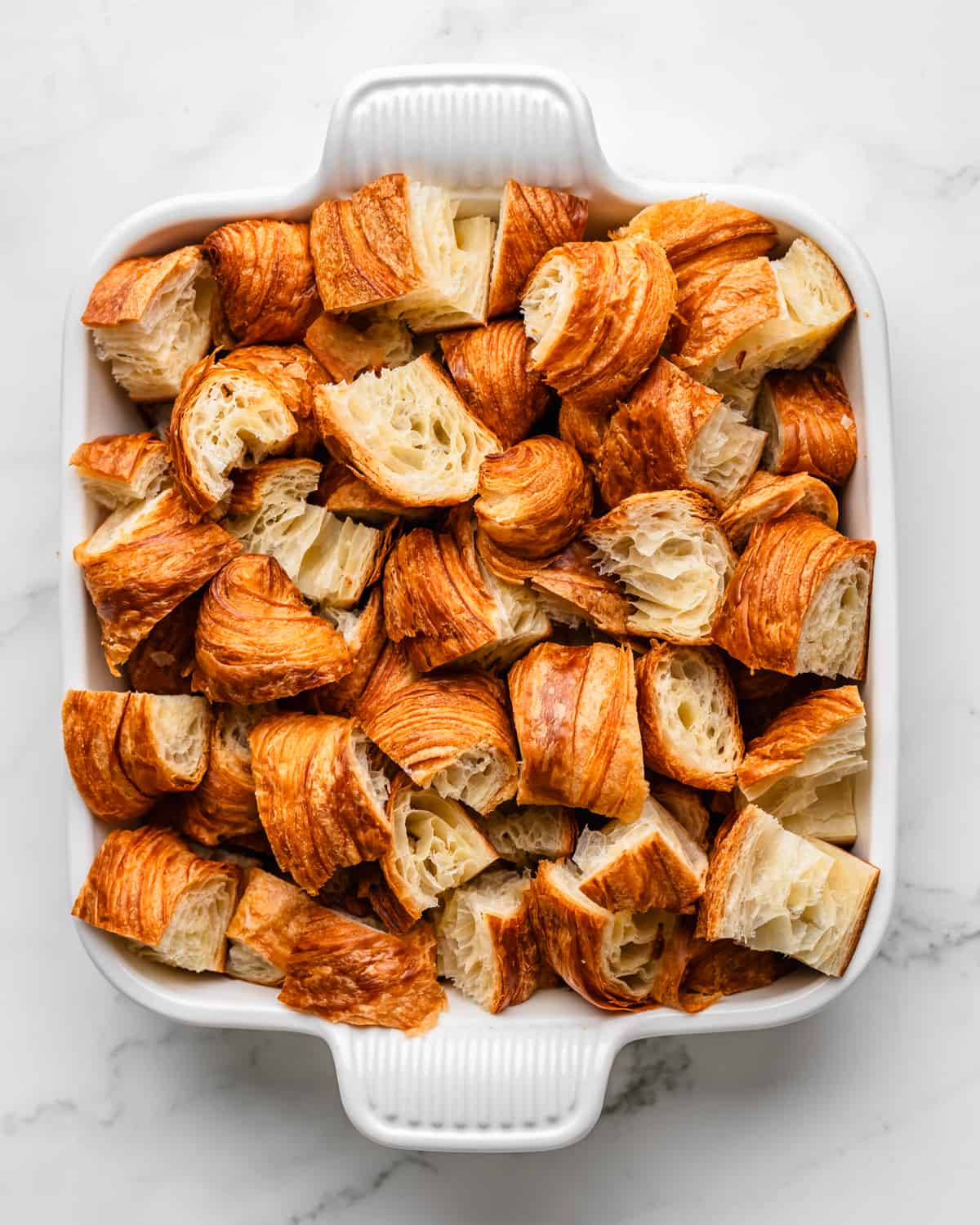 How to Make Croissant Bread Pudding - chopped croissants in a baking dish