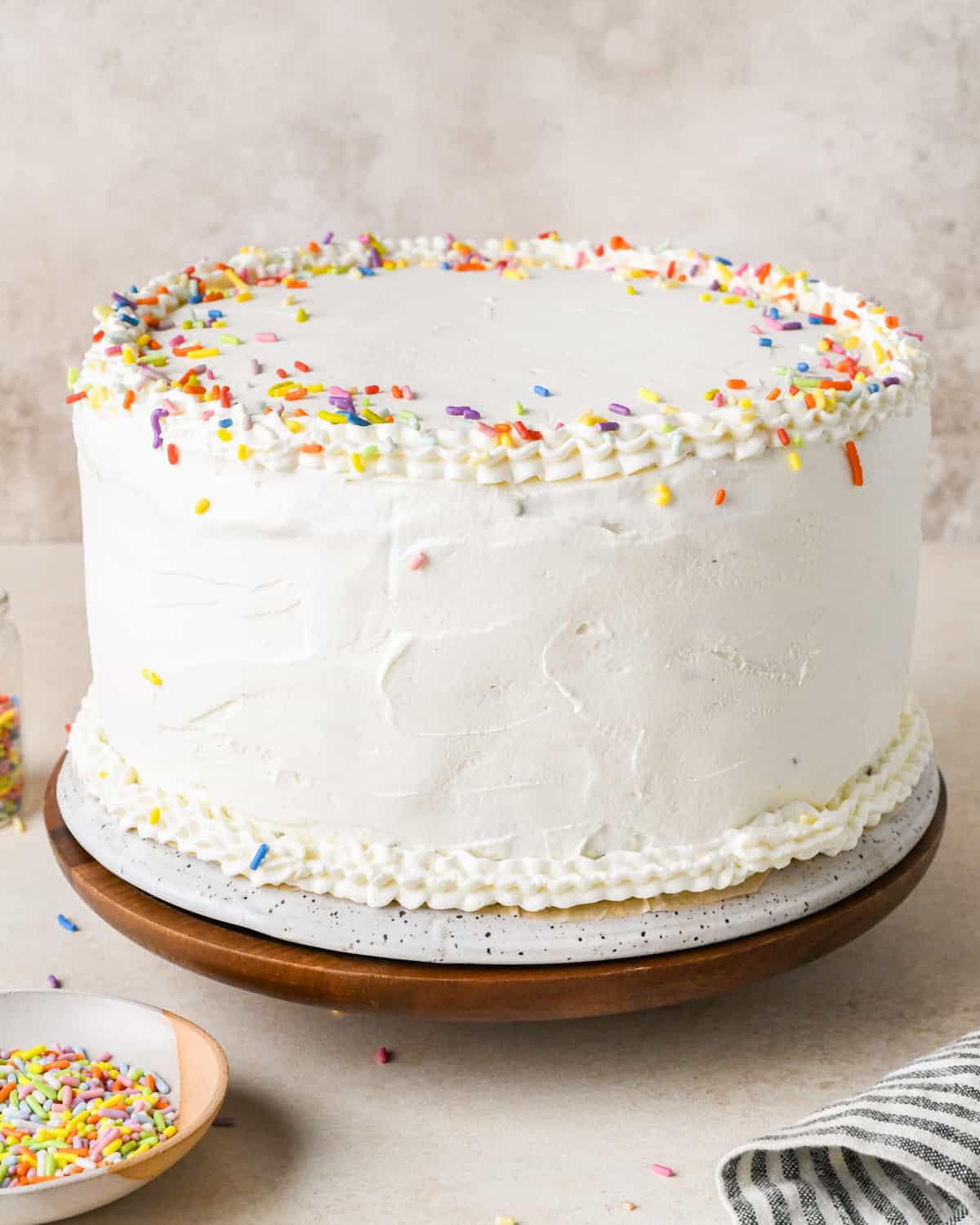 an ice cream cake frosted with whipped cream and decorated with sprinkles