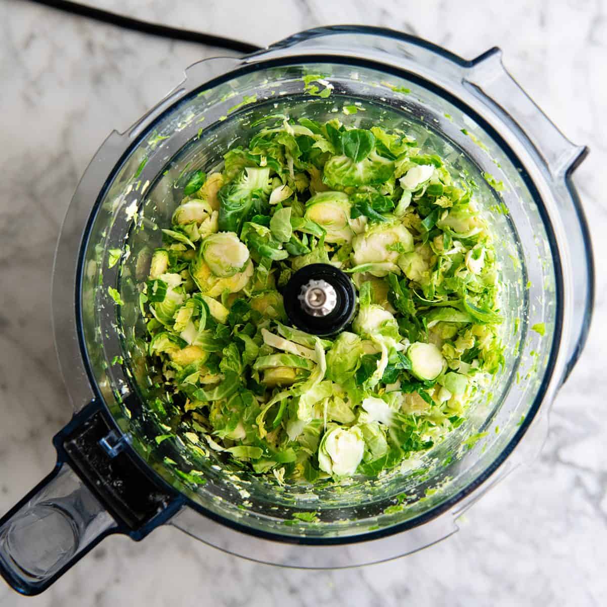 shredded brussels sprouts in a food processor to make Shredded Brussel Sprouts Salad