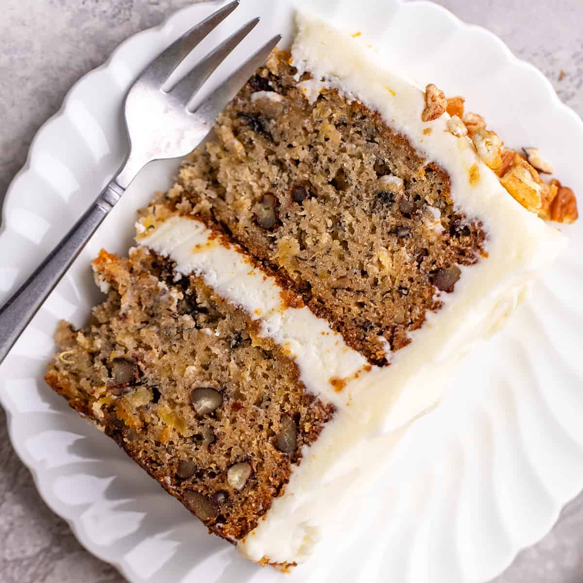 overhead photo of a slice of hummingbird cake on a plate with a fork