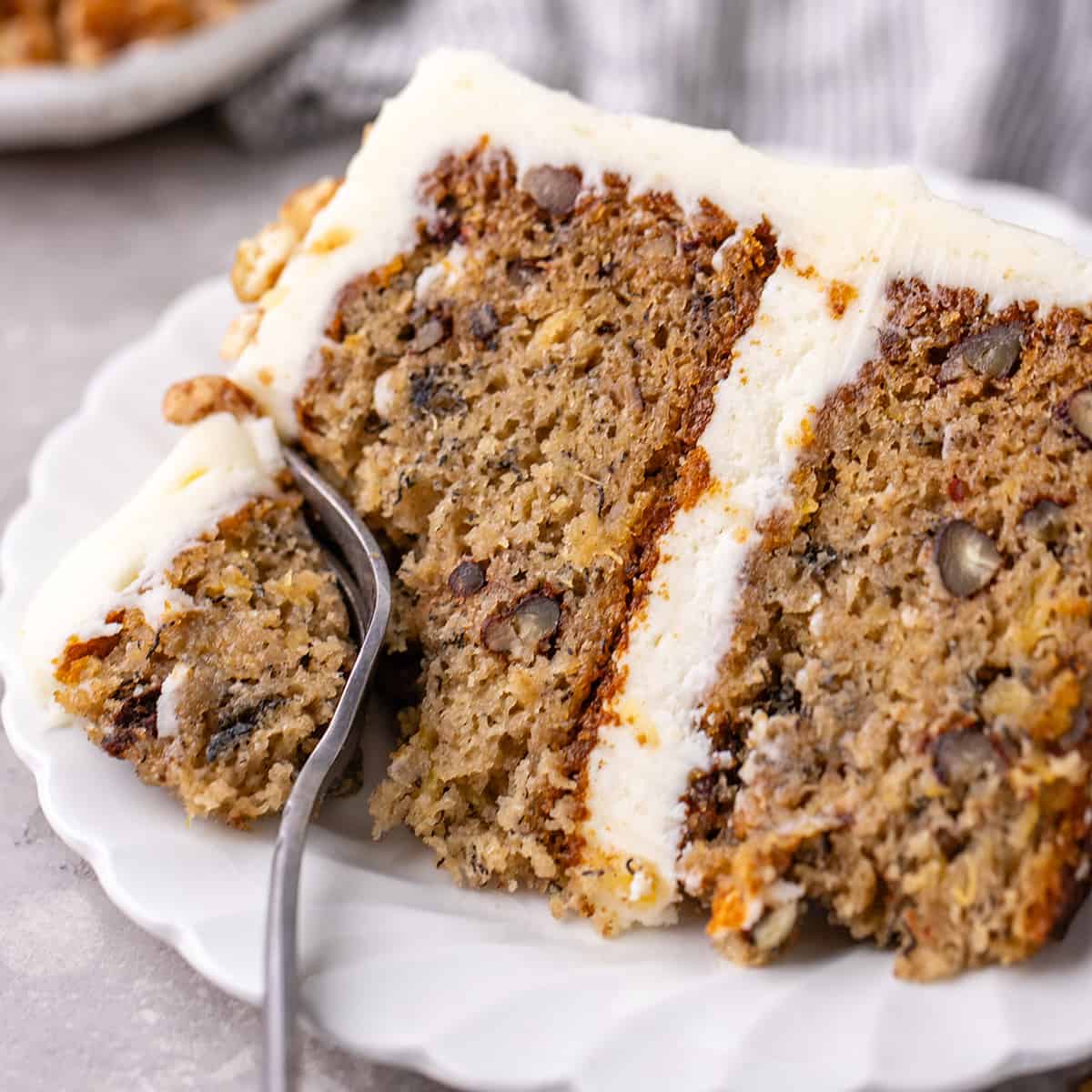 hummingbird cake on a plate with a fork taking a bite out of it