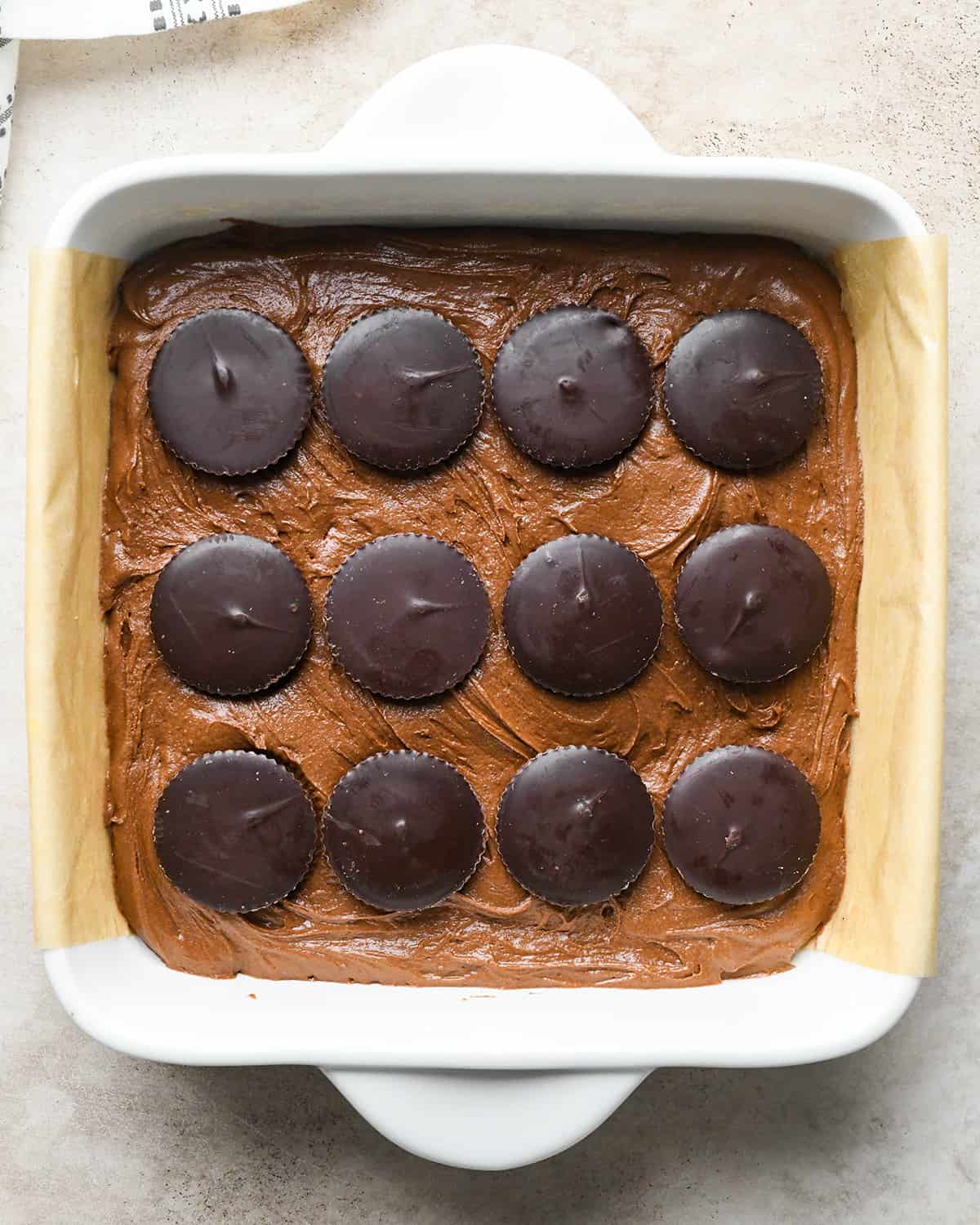 assembling Peanut Butter Cup Brownies - 12 peanut butter cups arranged in 3 rows on top of the brownie batter