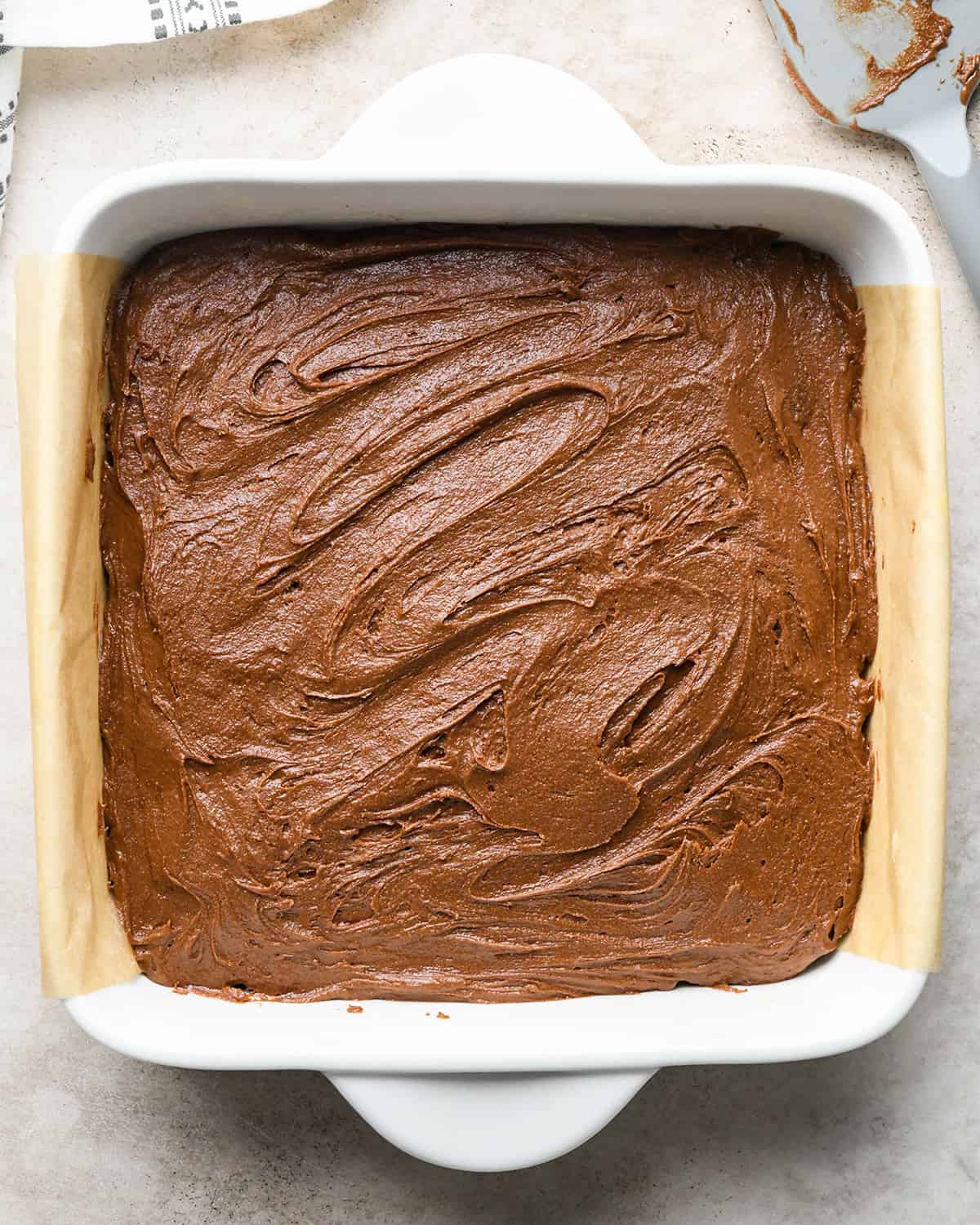 assembling Peanut Butter Cup Brownies - batter spread over peanut butter cups in baking dish