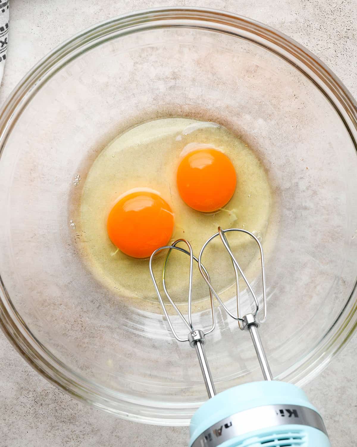 making Peanut Butter Cup Brownies - two eggs in a glass bowl before beating