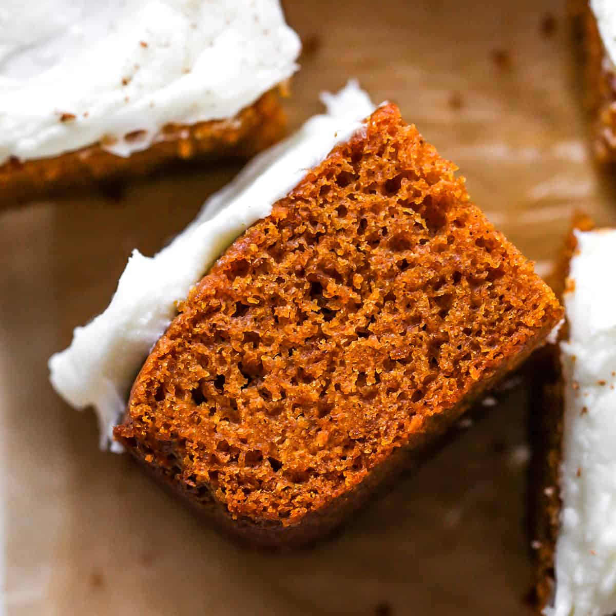 a piece of pumpkin cake on it's side with cream cheese frosting