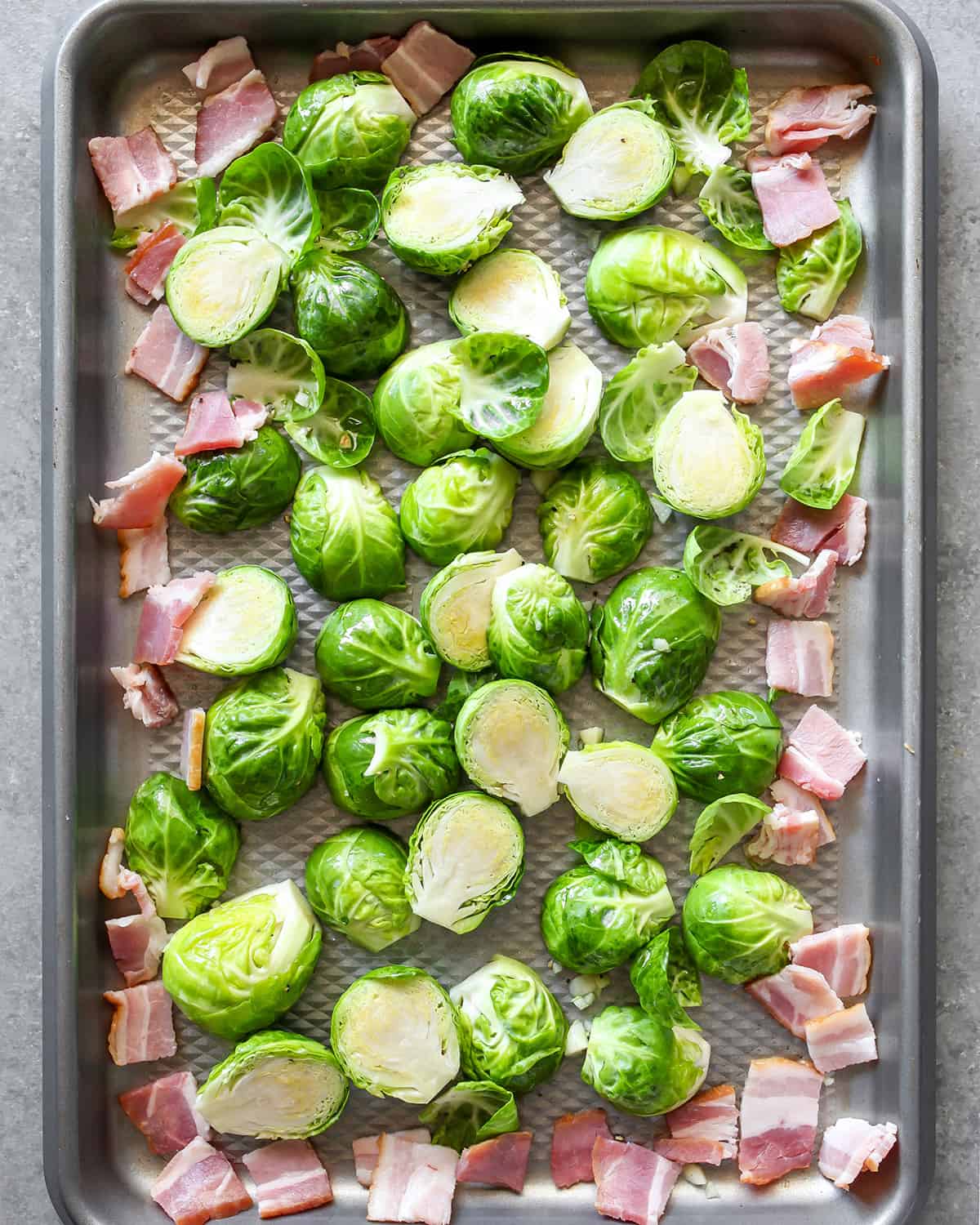 how to make brussel sprouts with bacon - ingredients on a pan before roasting