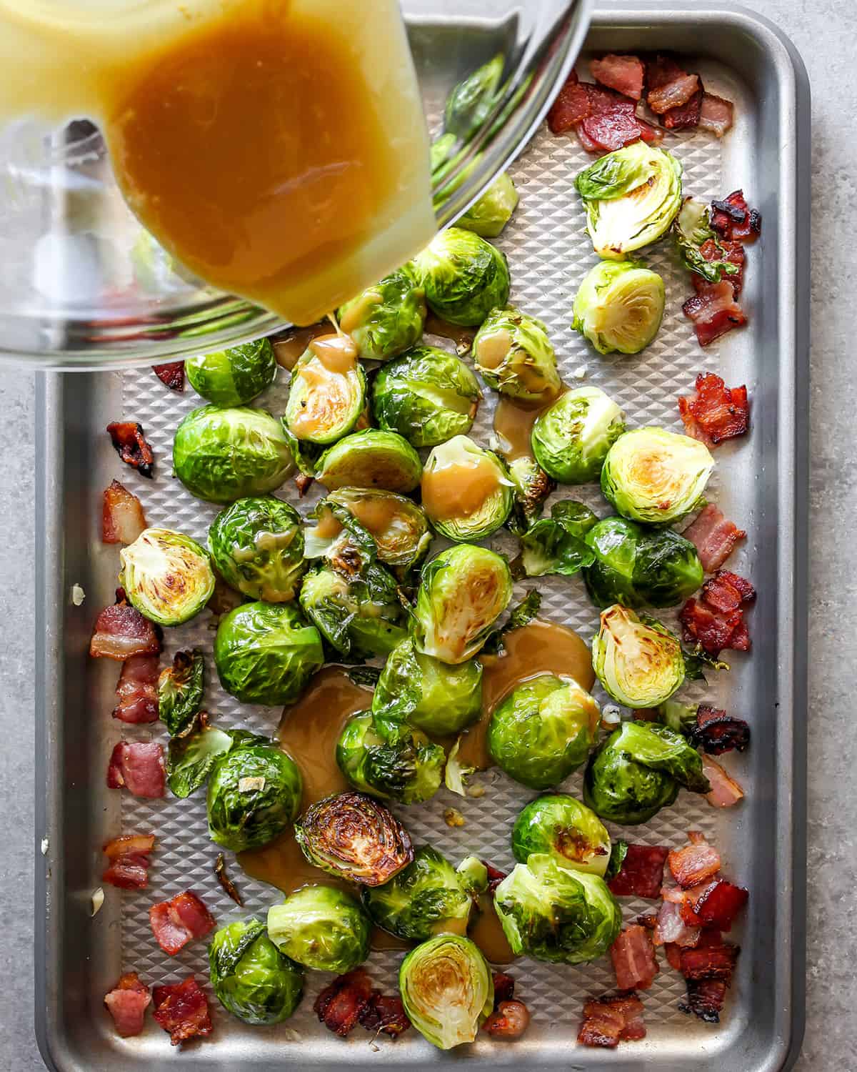 how to make brussel sprouts with bacon - pouring honey mustard sauce over sprouts