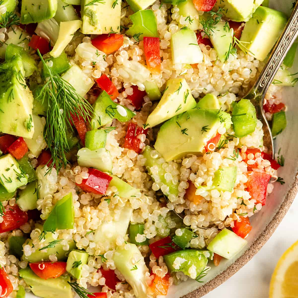 up close photo of a spoon taking a scoop of Quinoa Salad Recipe out of a bowl