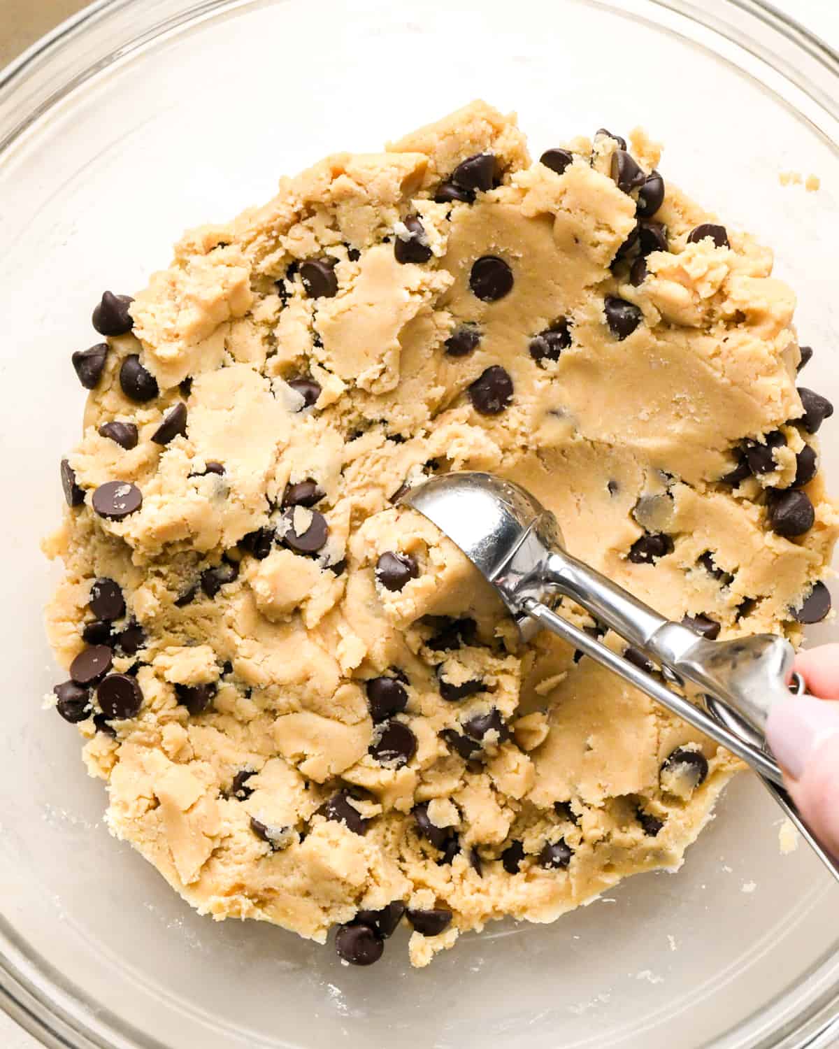 How to Make Vegan Chocolate Chip Cookies - a cookie scoop taking a portion of cookie dough