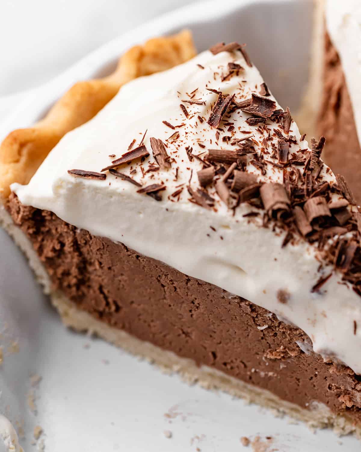close up shot of a slice of french silk pie in a white pie dish. 