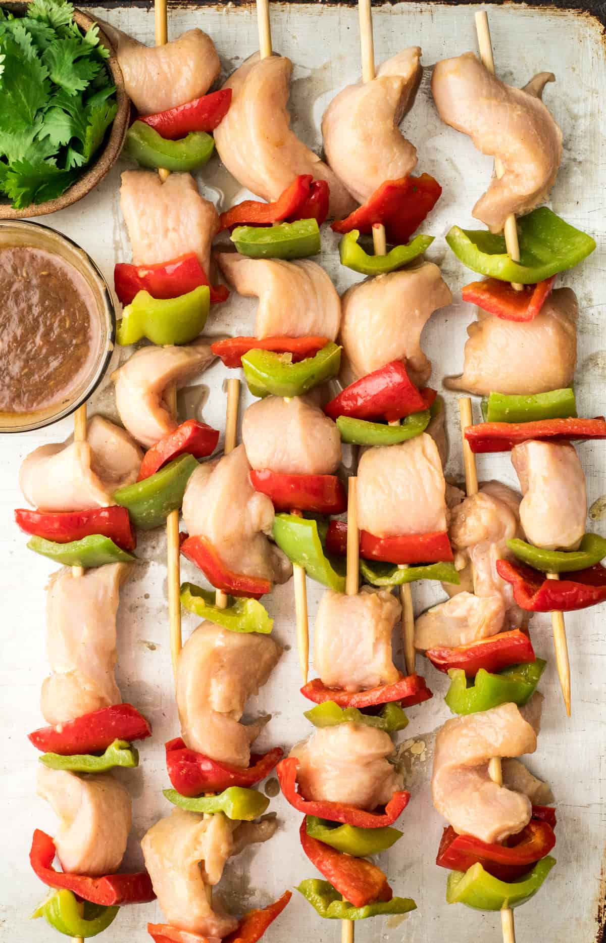 assembled chicken satay skewers on a pan before grilling