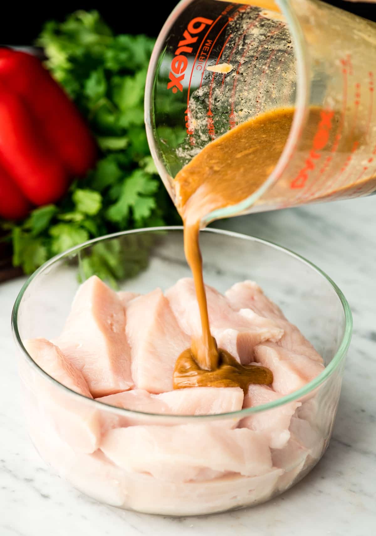 How to Make Chicken Satay - pouring marinade over chicken