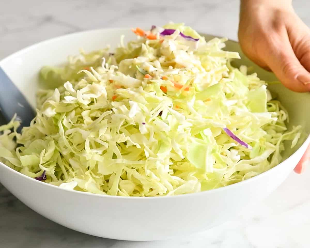 How to Make Coleslaw stirring the coleslaw in a bowl