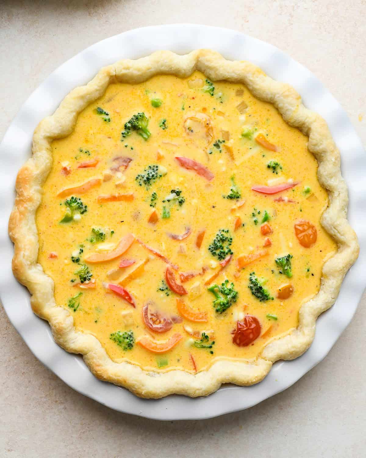 vegetable quiche in a pie dish before baking