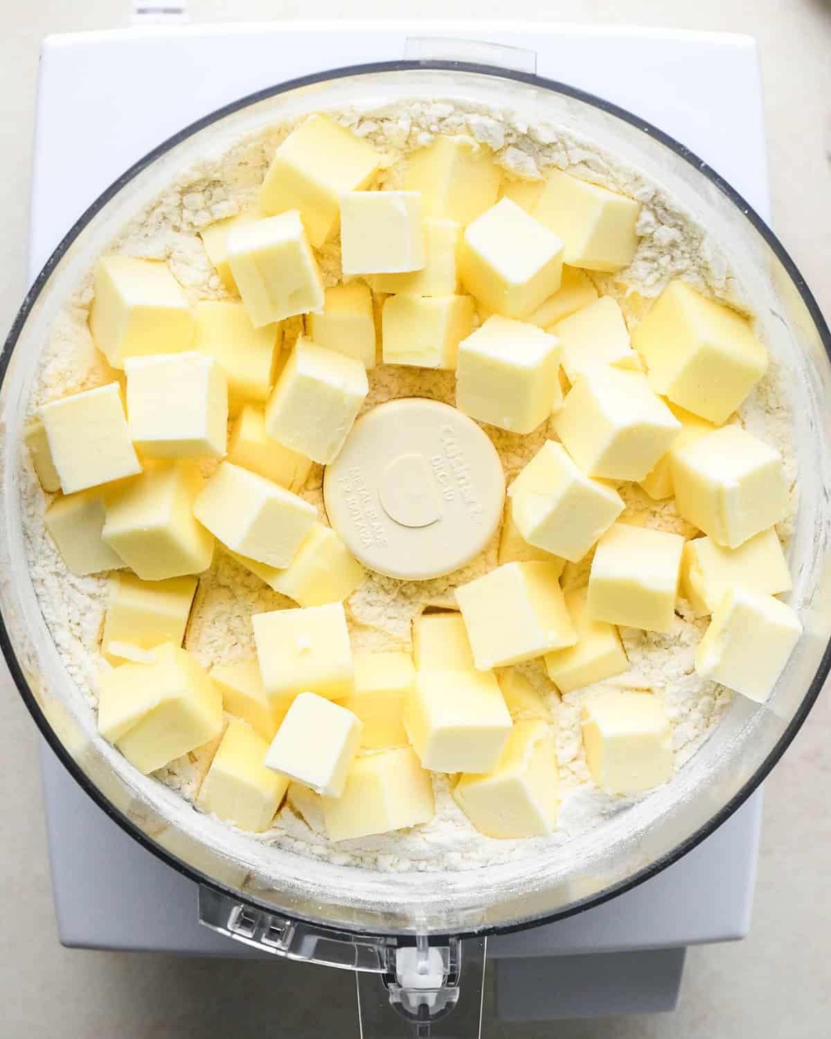 How to Make Quiche crust - butter and water added to the dry ingredients in a food processor before mixing