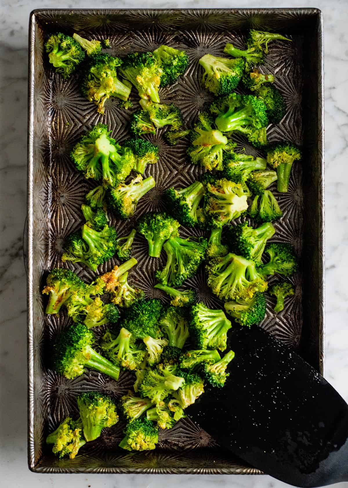 how to roast broccoli in the oven - broccoli on a baking sheet after roasting while stirring
