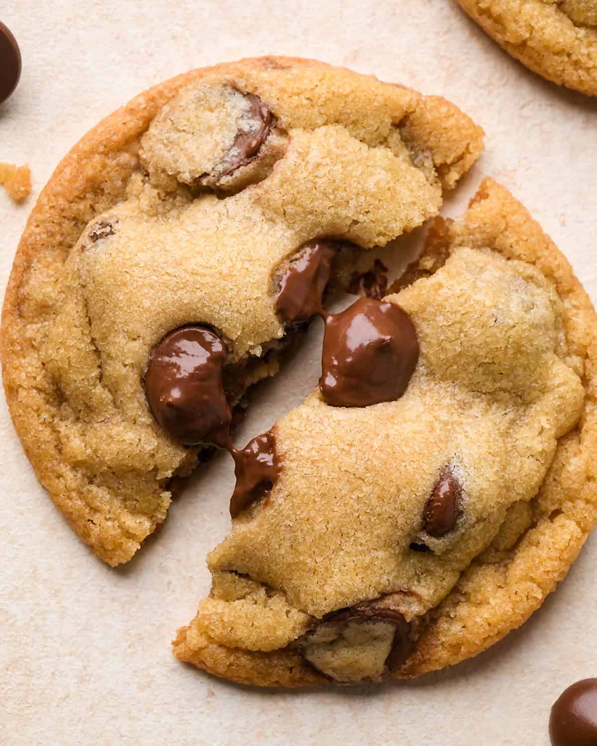 an Eggless Chocolate Chip Cookie cut in half with gooey chocolate chips